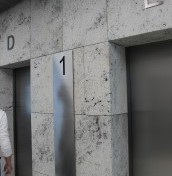 cyfry i litery oznaczające piętro przy wyjściu z windy