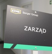 tabliczki z logo wbijane w ziemie przed autem